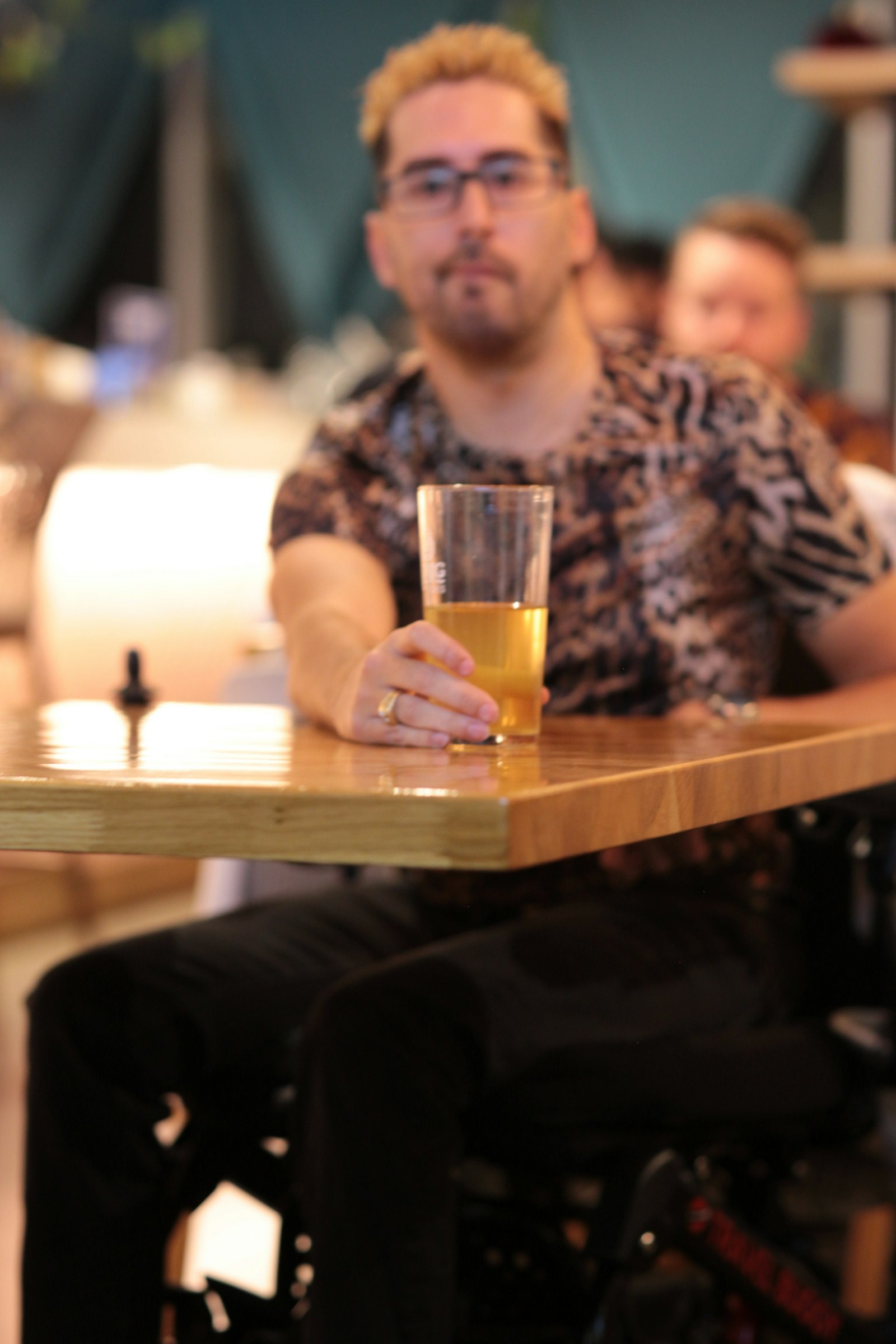 A patron enjoying a glass of craft beer at a taproom table